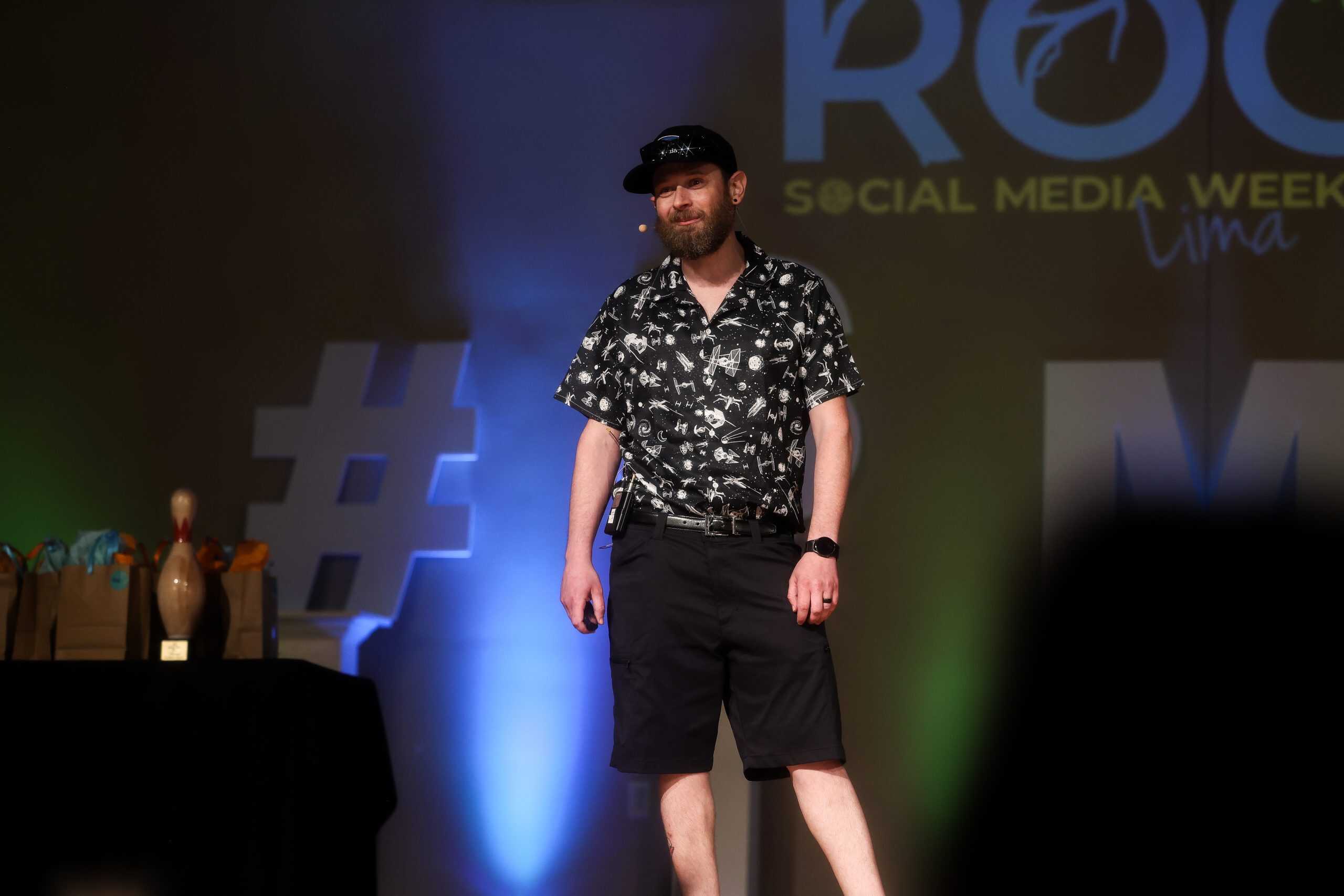 George smiling on stage during a speaking engagement